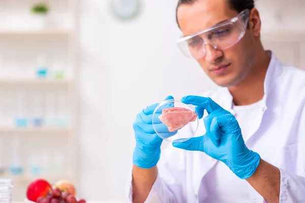 Jonge mannelijke voedingsdeskundige die voedingsproducten in het lab test — Stockfoto