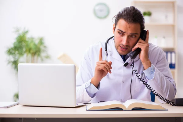 Genç doktor teletıp seansı sırasında hastayı dinliyor. — Stok fotoğraf