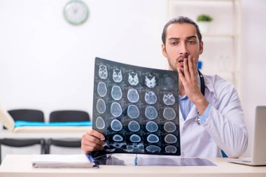 Klinikte çalışan yakışıklı genç erkek doktor.