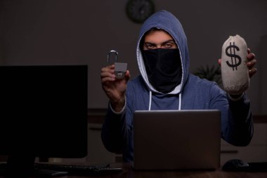 Erkek bilgisayar korsanı, güvenlik duvarını geç saatlerde hackliyor.