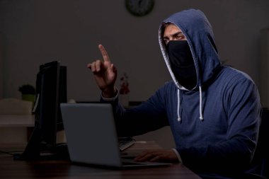 Erkek bilgisayar korsanı, güvenlik duvarını geç saatlerde hackliyor.