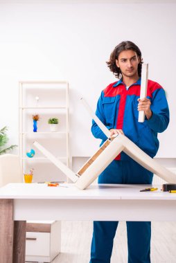 Genç erkek marangoz içeride çalışıyor.