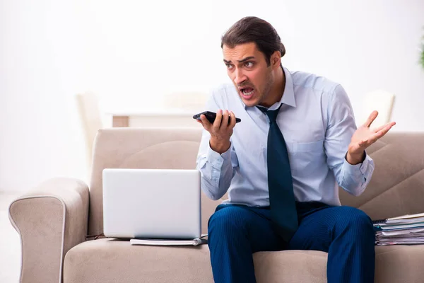 Jonge mannelijke werknemer die vanuit huis werkt — Stockfoto