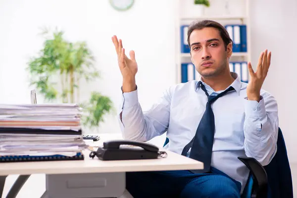 Jovem funcionário do sexo masculino infeliz com trabalho excessivo — Fotografia de Stock