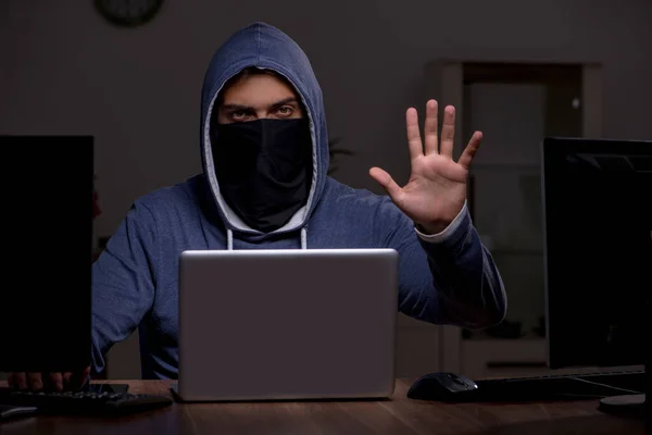 Hacker pria meretas firewall keamanan di kantor. — Stok Foto