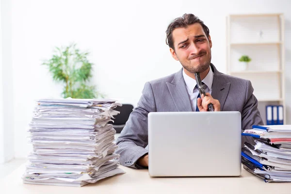 Joven empleado masculino infeliz con el trabajo excesivo —  Fotos de Stock