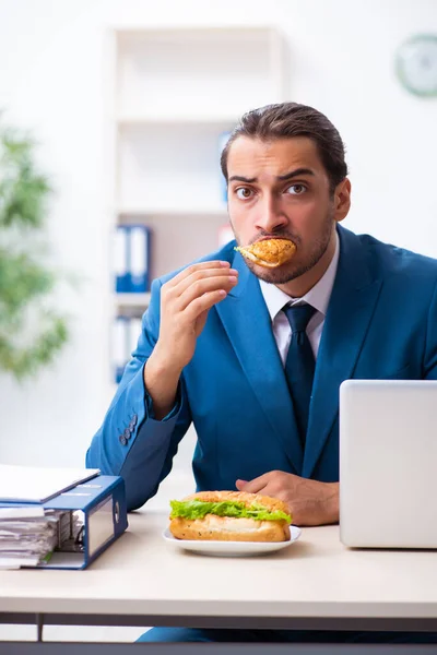 Giovane dipendente maschio che fa colazione sul posto di lavoro — Foto Stock