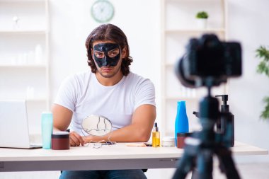 Genç erkek kozmetikçi blogu için video kaydediyor.