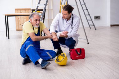 İlk yardım konseptinde genç erkek doktor ve yaşlı müteahhit.