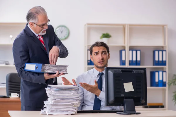 Oude baas en jonge mannelijke werknemer in het kantoor — Stockfoto