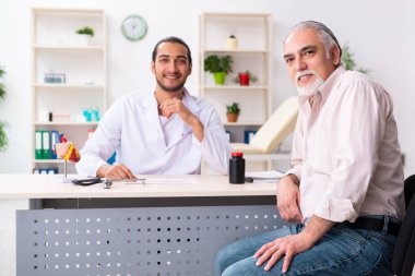 Yaşlı adam genç doktor kardiyoloğu ziyaret ediyor.