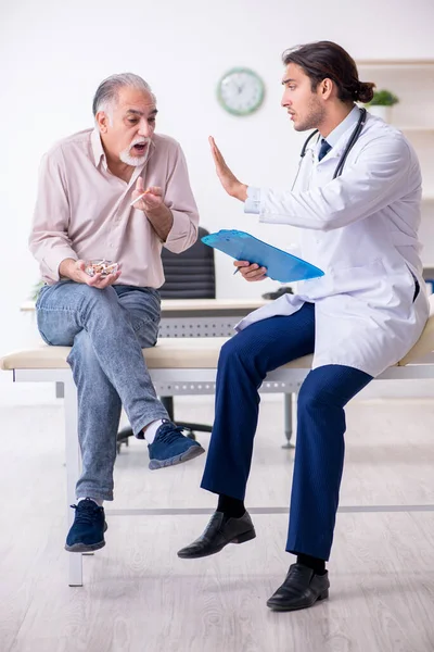 Ung manlig läkare och gammal patient i antirökningskoncept — Stockfoto