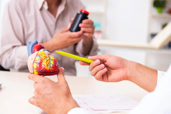 Yaşlı adam genç doktor kardiyoloğu ziyaret ediyor. — Stok fotoğraf