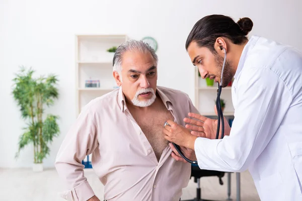 Yaşlı adam genç doktor kardiyoloğu ziyaret ediyor. — Stok fotoğraf