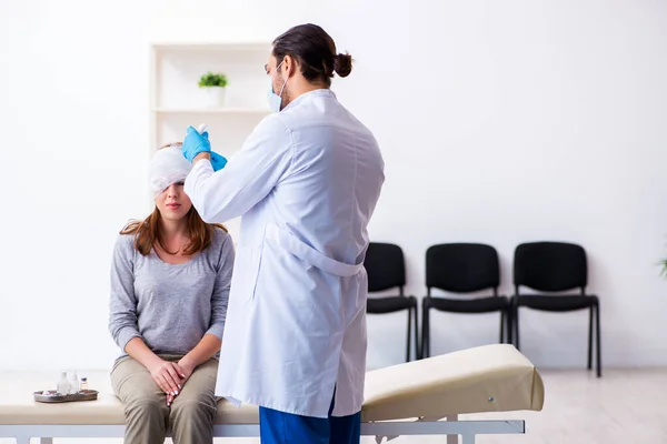 젊은 남성 의사를 방문하는 젊은 머리 부상 여성 — 스톡 사진