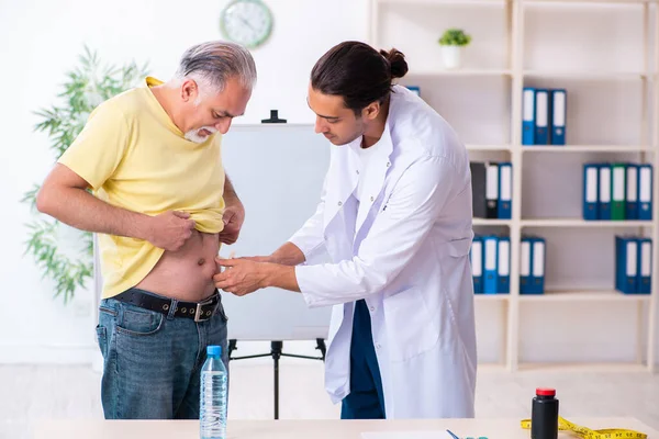 Médico dietista dando consejos a pacientes con sobrepeso de grasa —  Fotos de Stock