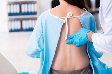 Yaralı genç kadın genç erkek doktoru ziyaret ediyor.