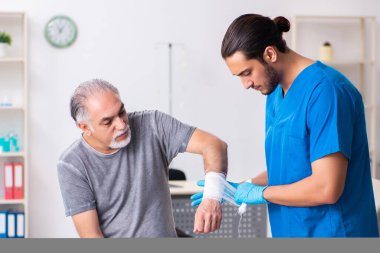 İlk yardım konseptinde genç erkek doktor ve yaşlı hasta.