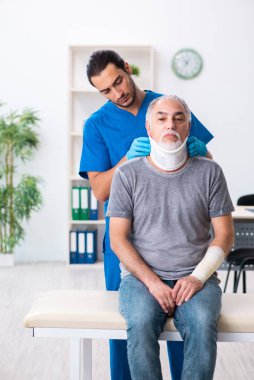 İlk yardım konseptinde genç erkek doktor ve yaşlı hasta.