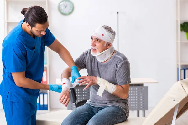 Junger Arzt und alter Patient im Erste-Hilfe-Konzept — Stockfoto