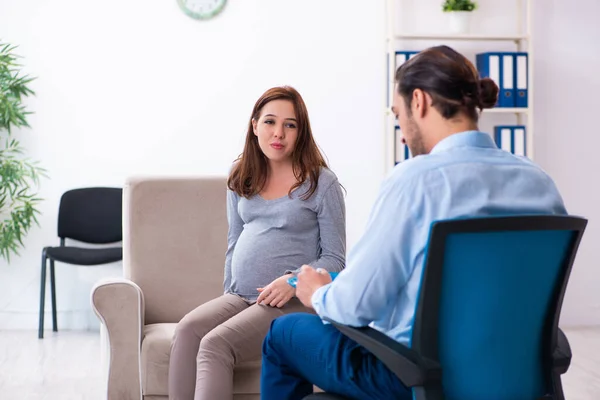 Zwangere vrouw op bezoek bij jonge mannelijke psycholoog — Stockfoto