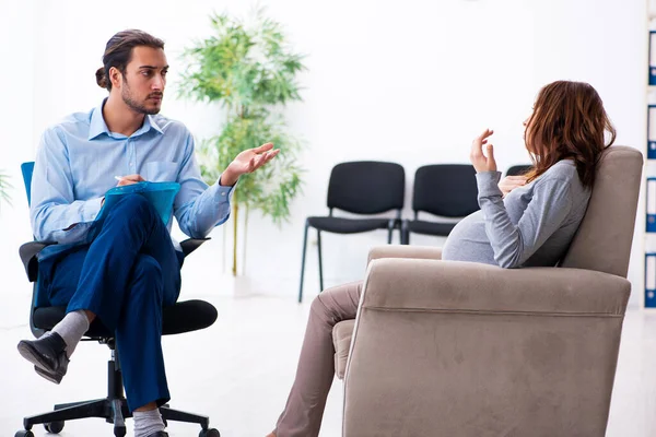 Zwangere vrouw op bezoek bij jonge mannelijke psycholoog — Stockfoto