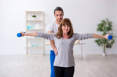 Kişisel koçla spor egzersizleri yapan genç bir kadın.