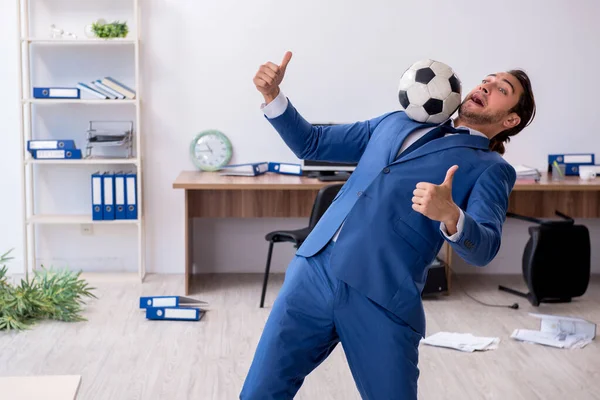 在办公室踢足球的年轻男性雇员 — 图库照片