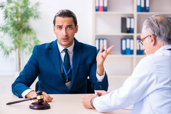 Adliyedeki erkek doktor avukatla toplantıda.