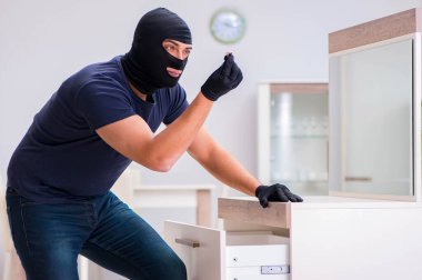 Soyguncu kar maskesi takıp değerli şeyler çalıyor.