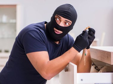 Soyguncu kar maskesi takıp değerli şeyler çalıyor.