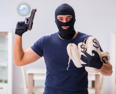 Soyguncu kar maskesi takıp değerli şeyler çalıyor.