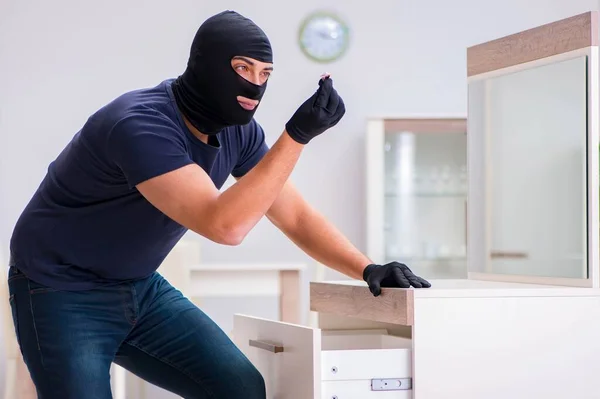 Ladrão usando balaclava roubando coisas valiosas — Fotografia de Stock