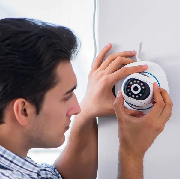 Man installing surveillance CCTV cameras at home