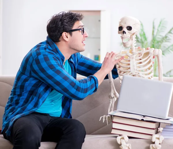 Estudiante estudiando con esqueleto preparándose para los exámenes —  Fotos de Stock