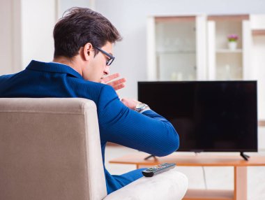 İş adamı ofiste televizyon izliyor.