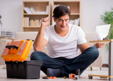 Evdeki rafları monte eden adam