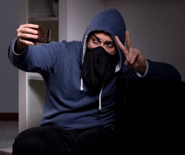 Hırsız, apartmandan televizyon çalıyor.