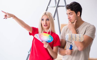 Ev tadilatı sırasında genç bir aile boya işi yapıyor.