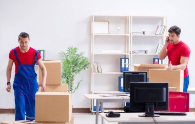 İki müteahhit personel kişisel eşyalarını taşıyor.