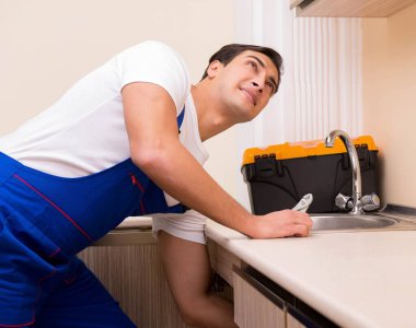 Mutfakta çalışan genç tamirci.