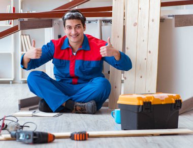 İnşaatta defter planlama yapan genç bir marangoz.