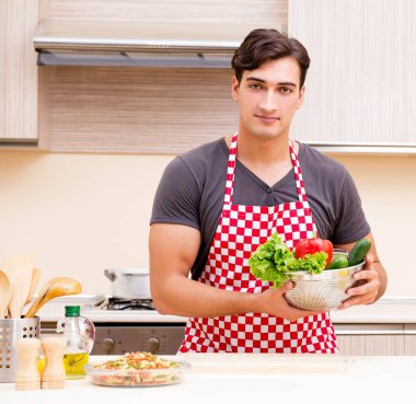 Erkek aşçı mutfakta yemek hazırlıyor.