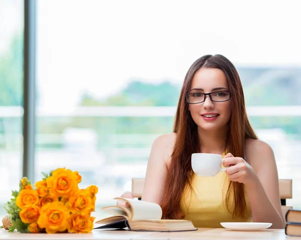 Jovem estudante bebendo café enquanto subitamente — Fotografia de Stock