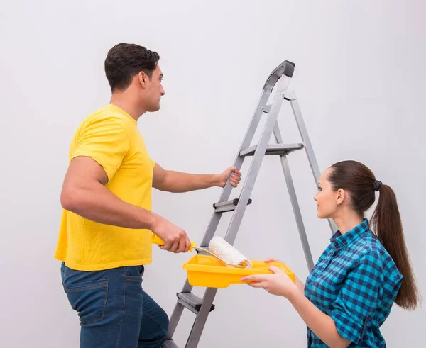 Jeune couple peinture mur à la maison — Photo