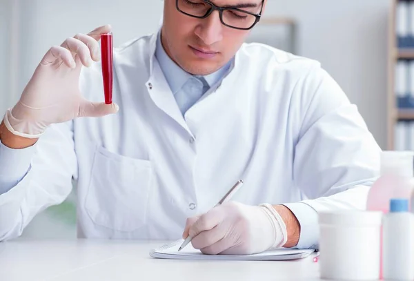 Jeune médecin dans le laboratoire avec tube rouge — Photo