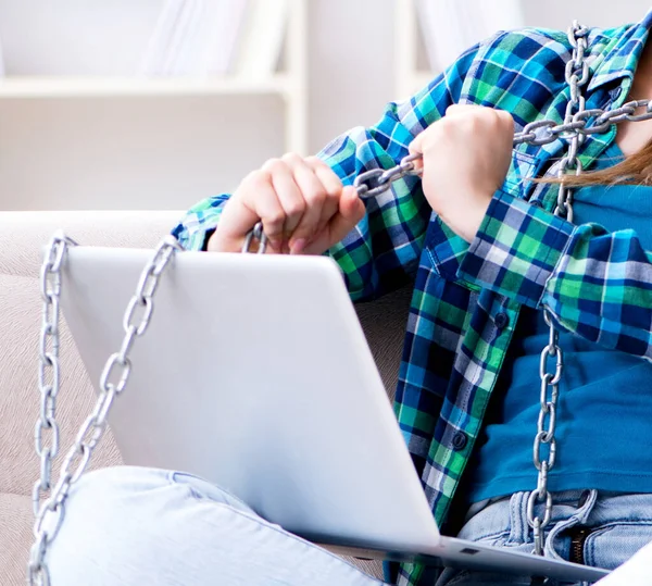 Spoutaná studentka s laptopem sedící na pohovce — Stock fotografie