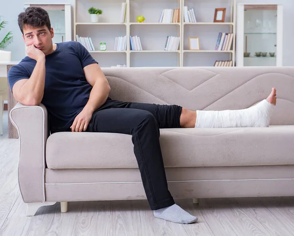 Homem com a perna partida a recuperar em casa — Fotografia de Stock