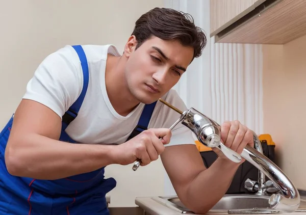 Joven reparador trabajando en la cocina — Foto de Stock