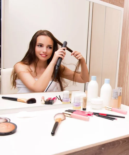 Mooie vrouw doet haar haar voor te bereiden voor feest — Stockfoto